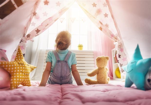 child sitting on bed window